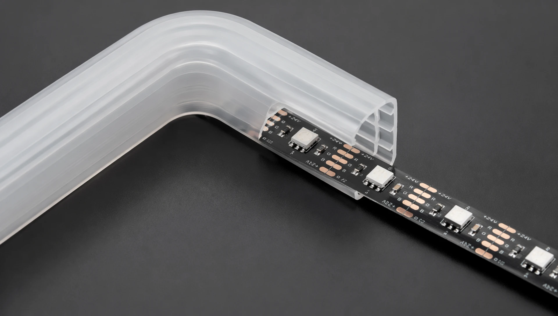 Detailed macro view of a separated rgb neon strip showing how the independent LED tape slides into the hollow silicone channel during custom sign fabrication. Detailed macro view of a separated rgb neon strip showing how the independent LED tape slides into the hollow silicone channel during custom sign fabrication.